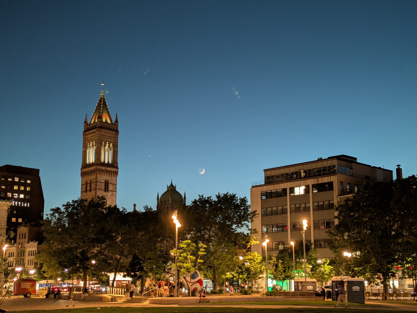 A night shot of Trinity Church with the moon rising over it.