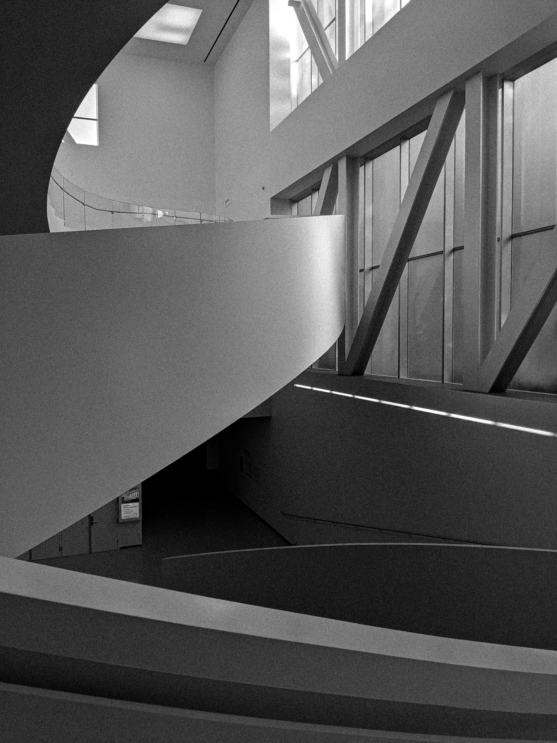 Curved walls and angled supports frame a window in this modern building's interior.