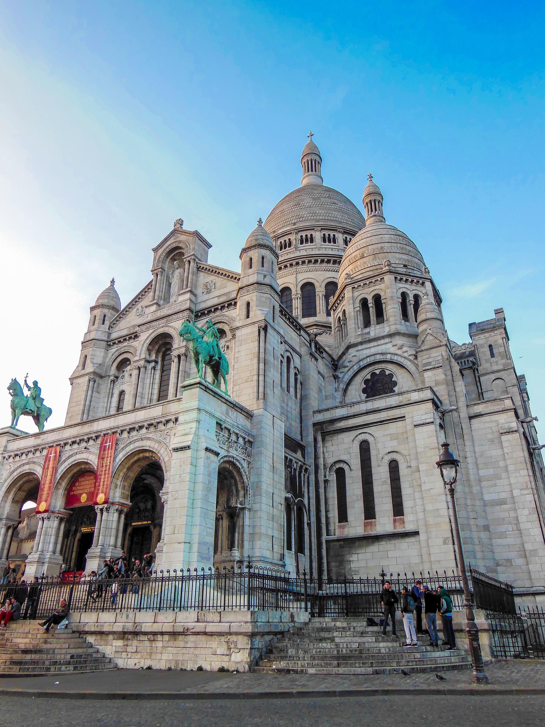 The Sacré-Cœur Basilica and equestrian statue stand prominently on a hill in Paris.