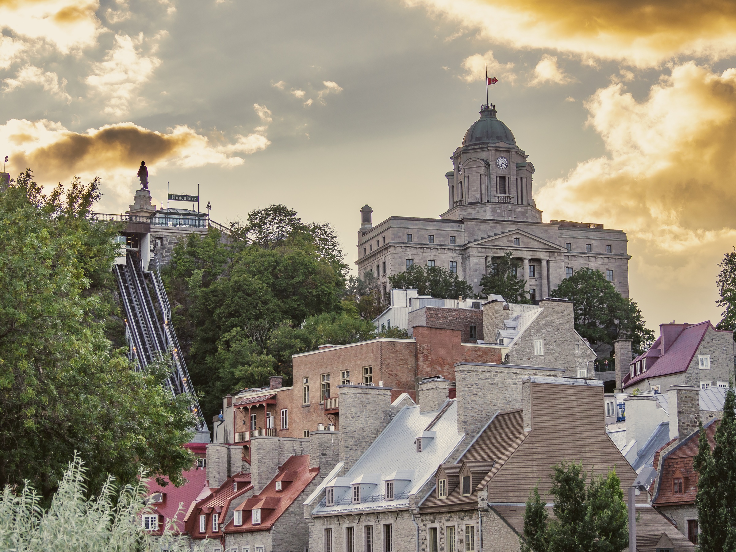 Quebec City's historic buildings and the iconic Citadelle rise above a sloping, tree-lined cityscape.