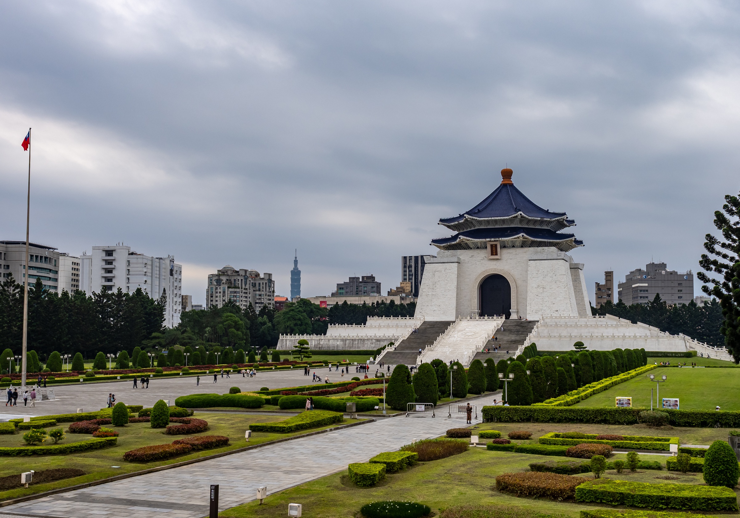 The Chiang Kai-shek Memorial Hall stands prominently in a large, landscaped park with city buildings beyond.