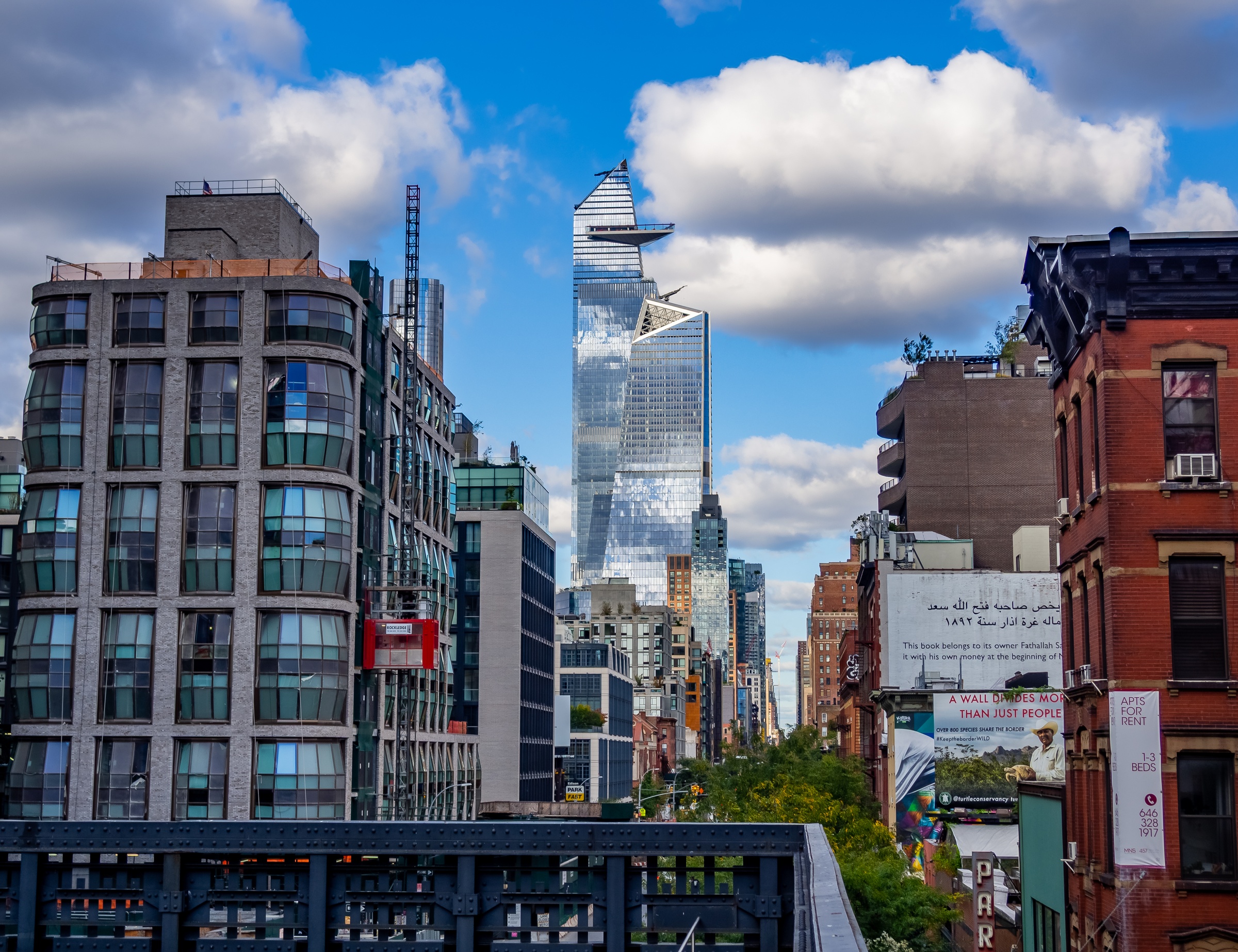 Modern skyscrapers rise above older buildings in a vibrant New York City streetscape.