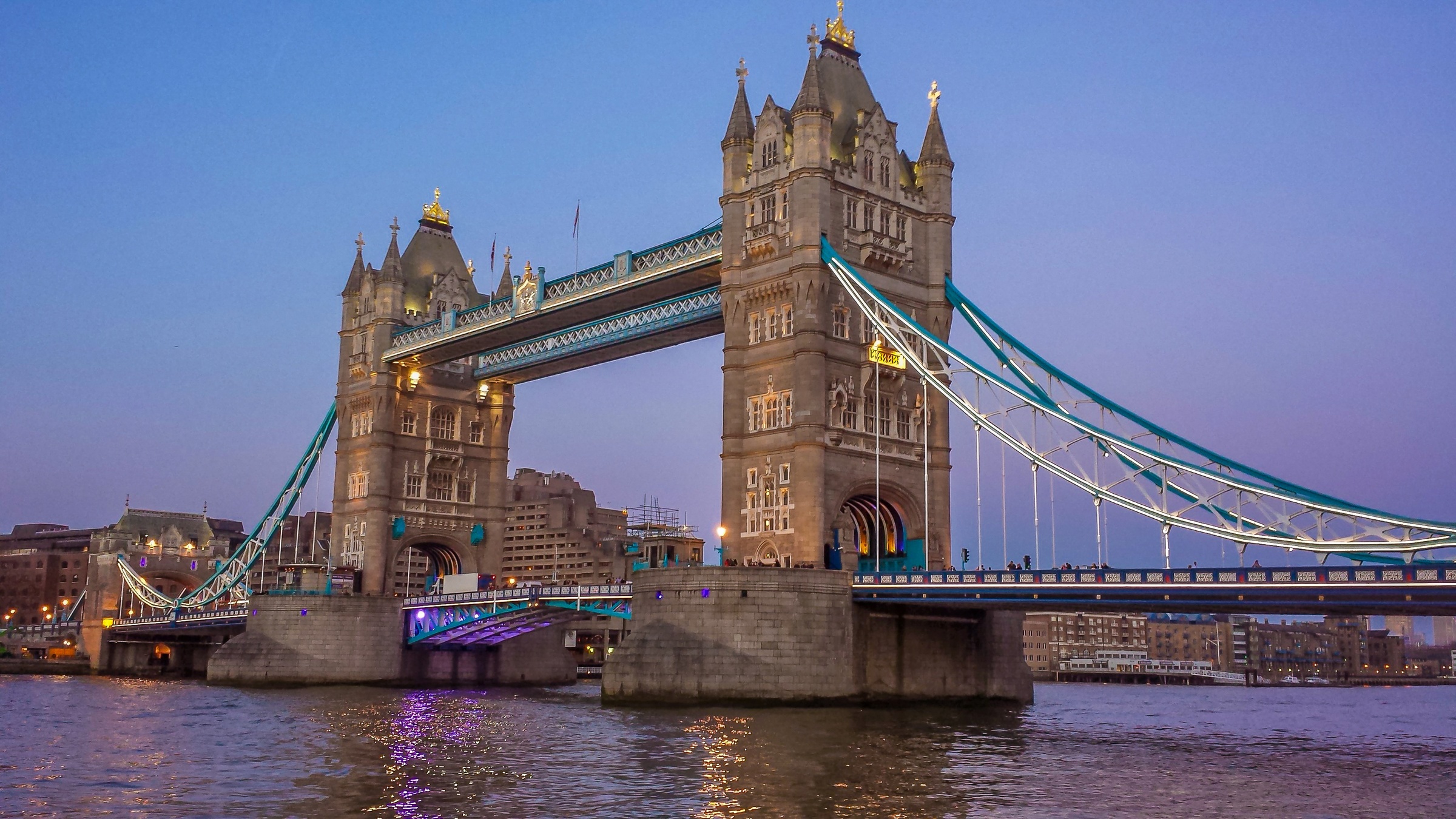 Tower Bridge spans the River Thames at dusk in London.