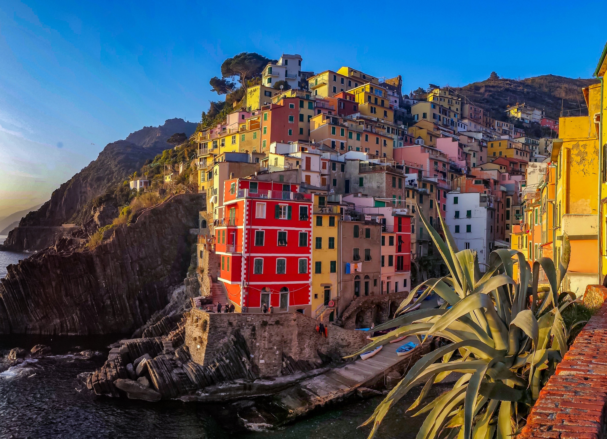 Colorful houses cluster on a rocky cliff overlooking the sea.