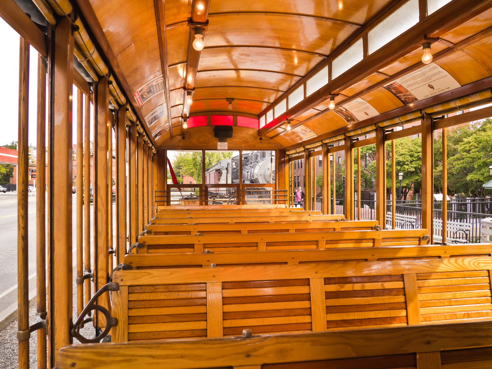 Seats on a trolley car, wooden, in golden light.